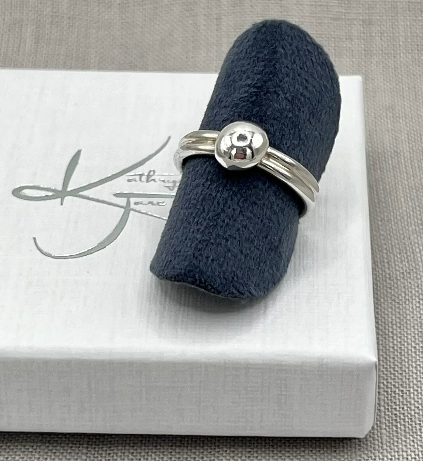 Sterling silver double band ring with polished nugget detail on a display box
