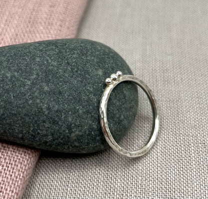 Silver ring on a stone with a soft fabric background